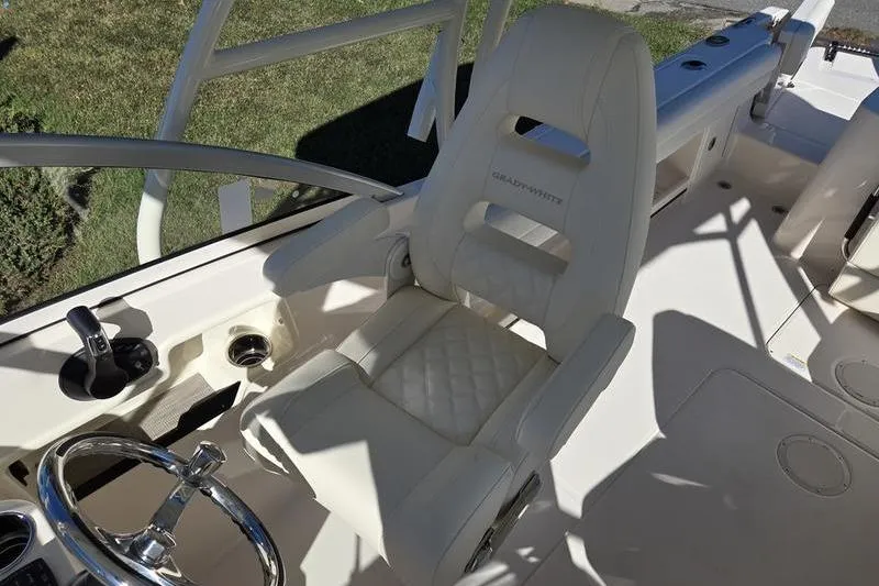 Slide: The Image of 2026 Grady-White Freedom 235 boat seat with elegant white upholstery and cup holders. - 21
