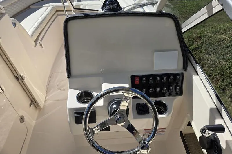 Slide: The Image of 2026 Grady-White Freedom 235 boat helm with steering wheel and control panel. - 22