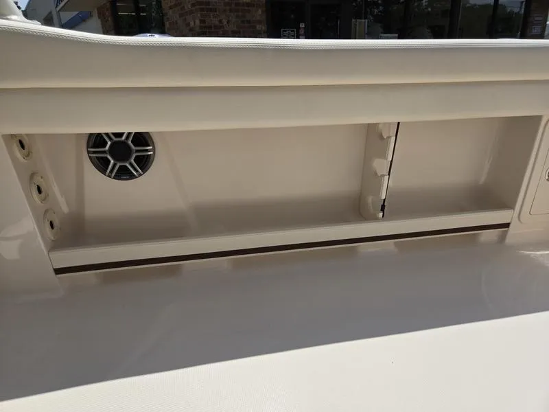 Slide: The Image of 2026 Grady-White Freedom 235 boat interior with open storage compartment and cushioned seating. - 4