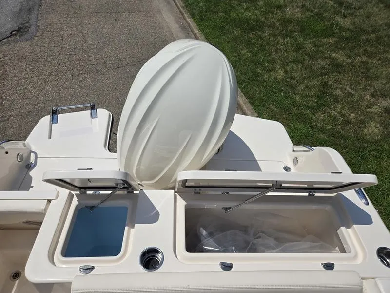 Slide: The Image of 2026 Grady-White Freedom 235 boat with open storage compartments and outboard motor. - 8