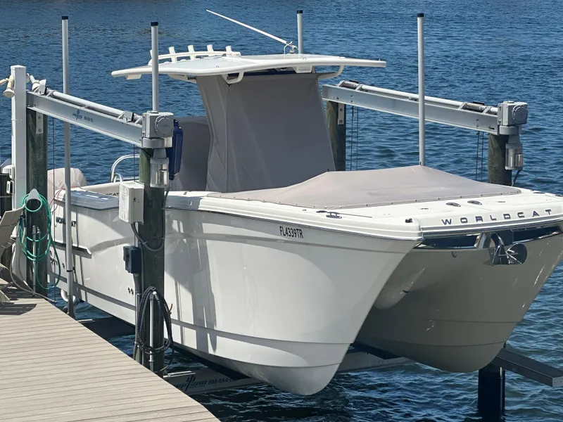 Slide: The Image of 2024 World Cat 280ccx boat docked on a lift by the water. - 2
