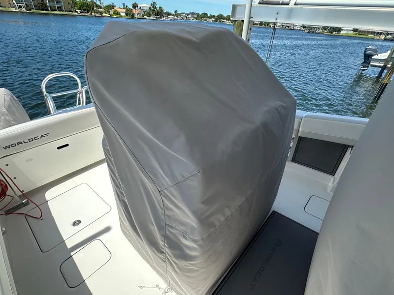 Slide: The Image of 2024 World Cat 280ccx boat interior with covered console, docked by the water. - 31