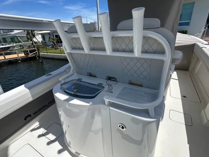 Slide: The Image of 2024 World Cat 280ccx boat interior with rod holders and storage, docked by waterfront homes. - 39