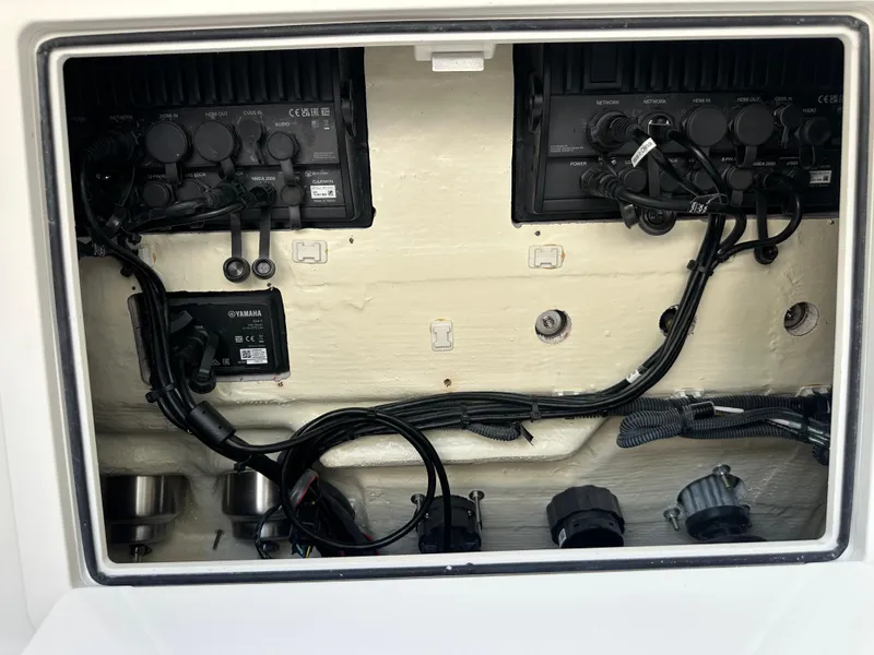 Slide: The Image of 2024 World Cat 280ccx boat electronics compartment with Yamaha components and wiring. - 41