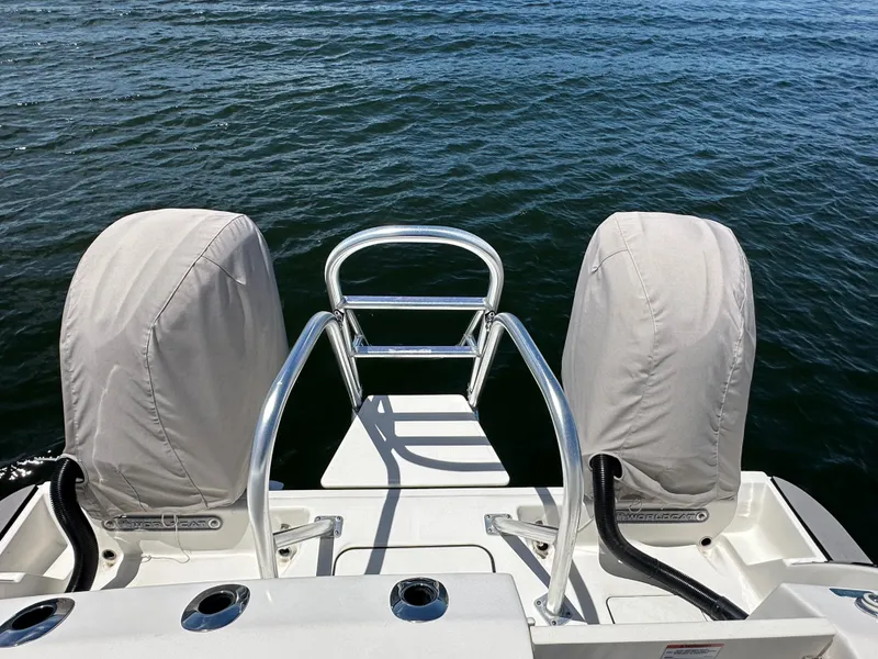 Slide: The Image of 2024 World Cat 280ccx boat with covered engines, rear view over water. - 48