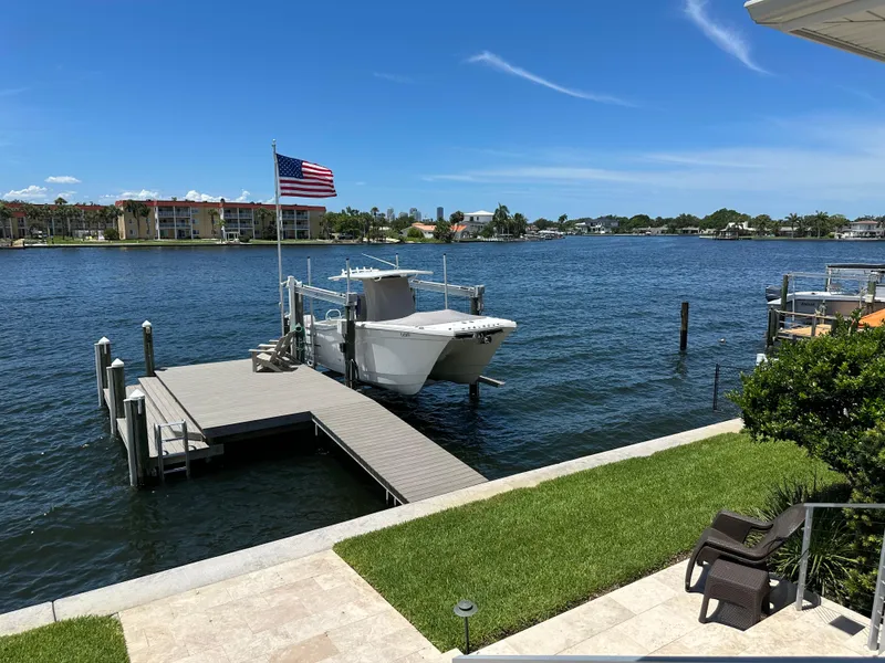 Slide: The Image of 2024 World Cat 280ccx boat docked by waterfront with American flag, sunny day. - 6