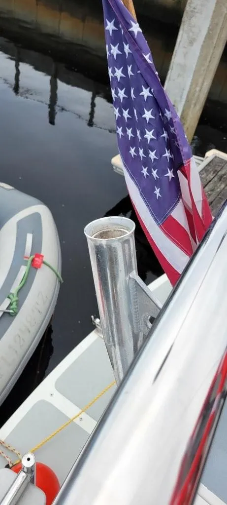 Slide: The Image of American flag on a 2001 Monk 36 boat docked by the water. - 16