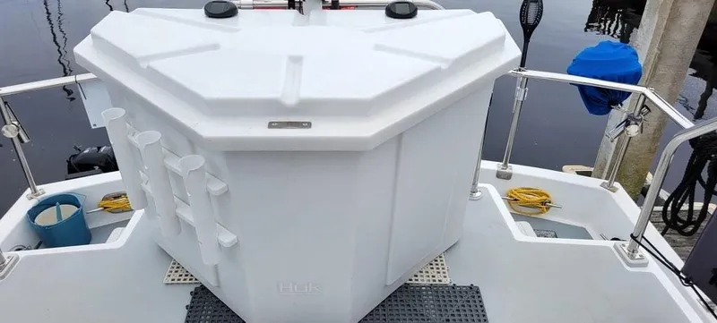 Slide: The Image of White deck storage on 2001 Monk 36 boat, featuring rod holders and safety rails. - 21