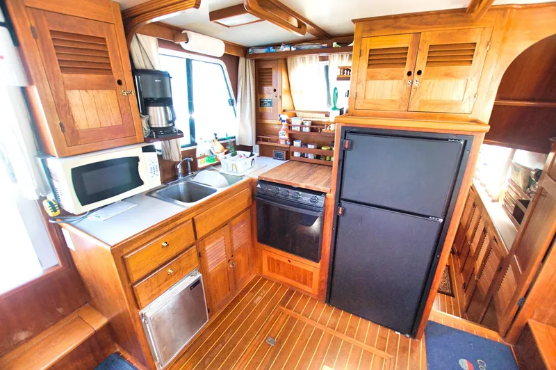 Slide: The Image of Wooden kitchen interior of 2001 Monk 36 boat, featuring appliances and ample storage. - 29
