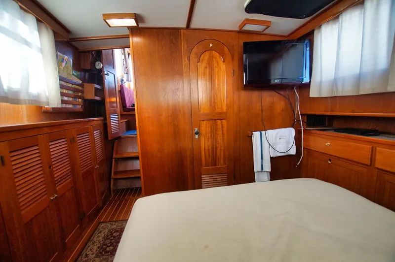 Slide: The Image of Interior of 2001 Monk 36 boat, featuring wood paneling, TV, and cozy cabin space. - 34