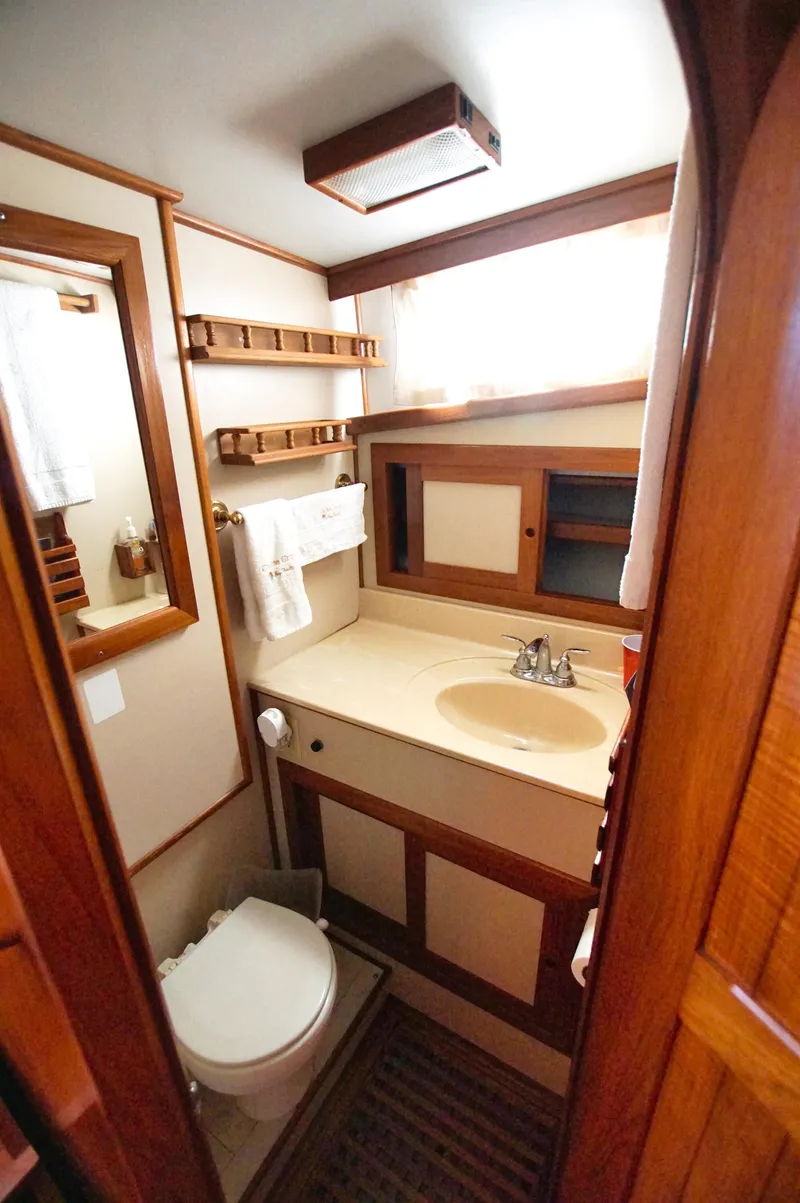 Slide: The Image of Bathroom interior of 2001 Monk 36 (Hull #215) yacht, featuring sink, toilet, and wooden cabinetry. - 36