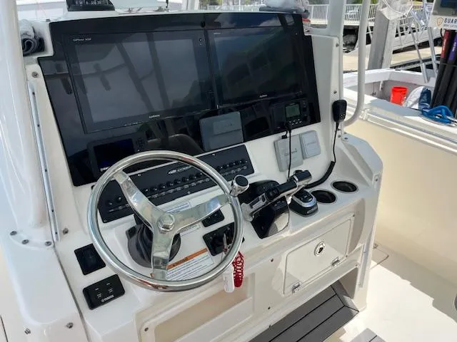 Slide: The Image of 2019 Cobia 320 Center Console helm with steering wheel and navigation controls. - 14