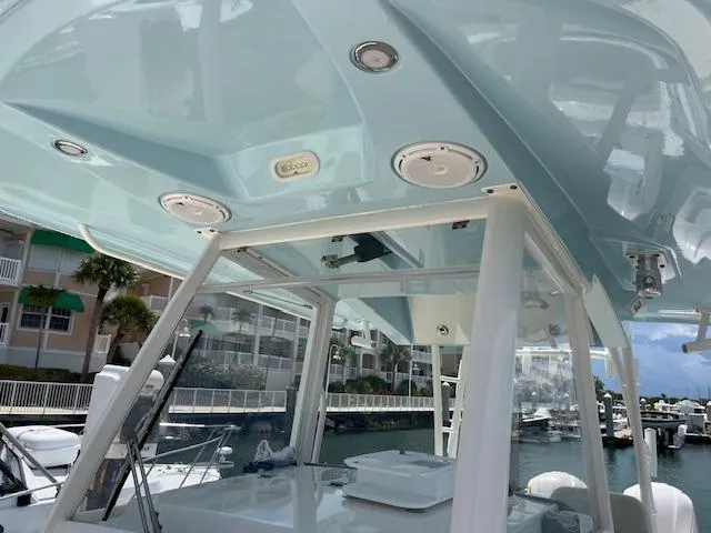 Slide: The Image of 2019 Cobia 320 Center Console boat with sleek design, docked at marina. - 18