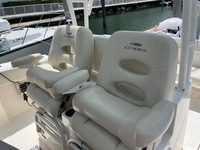 Slide: The Image of 2019 Cobia 320 Center Console boat with plush white seating. - 23