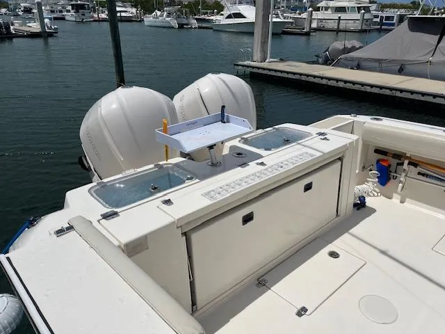 Slide: The Image of 2019 Cobia 320 Center Console boat with dual engines at marina dock. - 26