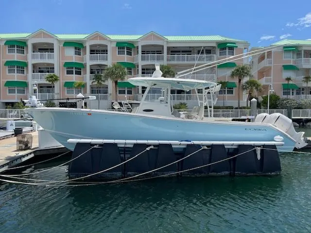 Slide: The Image of 2019 Cobia 320 Center Console boat docked near waterfront apartments. - 4