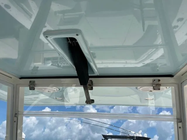 Slide: The Image of 2019 Cobia 320 Center Console boat interior with clear sky view through the roof hatch. - 9