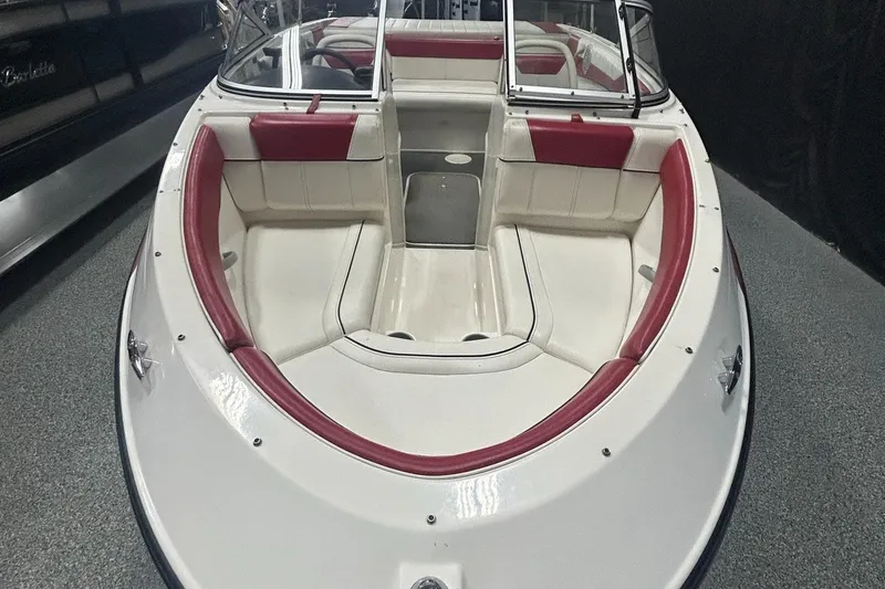 Slide: The Image of 2013 Bayliner 185 Bowrider boat with red and white seating, viewed from the bow. - 7