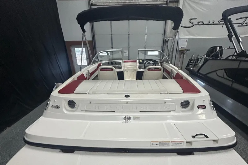 Slide: The Image of 2013 Bayliner 185 Bowrider boat with red and white interior, displayed indoors. - 8