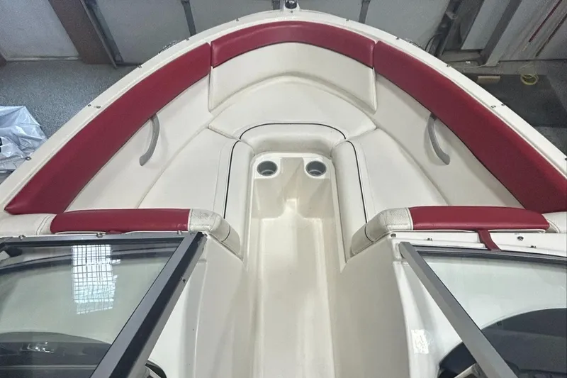 Slide: The Image of 2013 Bayliner 185 Bowrider interior with red and white seating, viewed from above. - 9