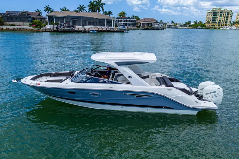 Slide: The Image of 2017 Sea Ray 31 SLX boat on calm water near waterfront homes. - 10