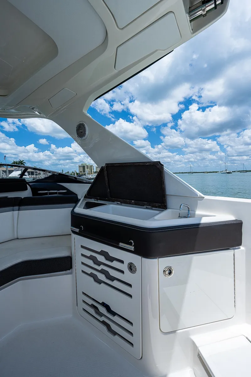 Slide: The Image of 2017 Sea Ray 31 SLX boat interior with seating and storage under a blue sky. - 18