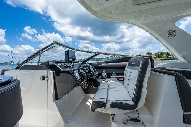 Slide: The Image of 2017 Sea Ray 31 SLX boat interior with helm and seating, under a blue sky. - 25