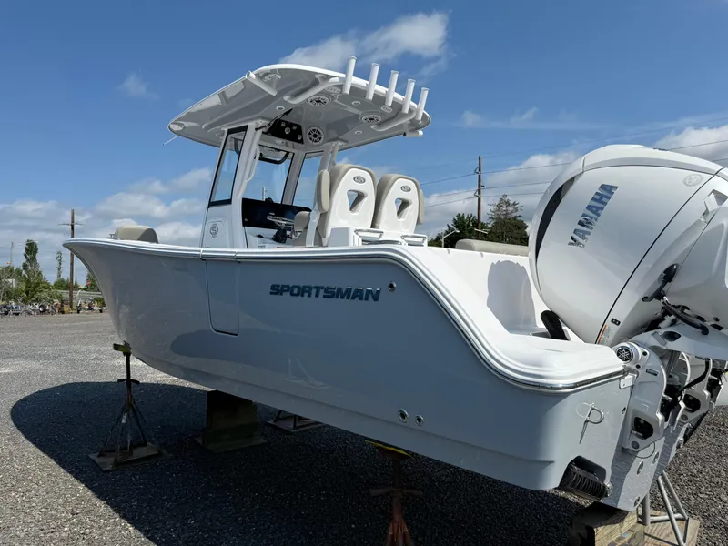 Slide: The Image of 2025 Sportsman Open 262 Center Console boat with Yamaha engine, displayed outdoors. - 2