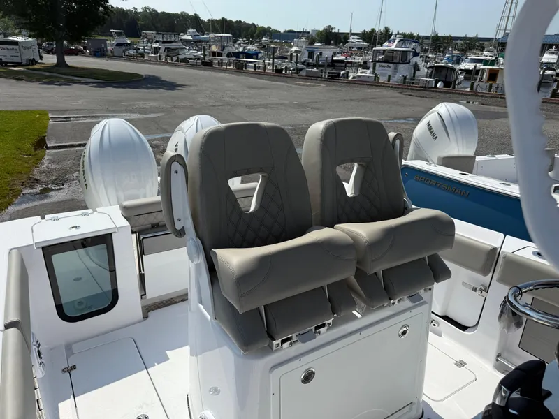 Slide: The Image of 2025 Sportsman Open 262 Center Console boat interior with dual seats at marina. - 5