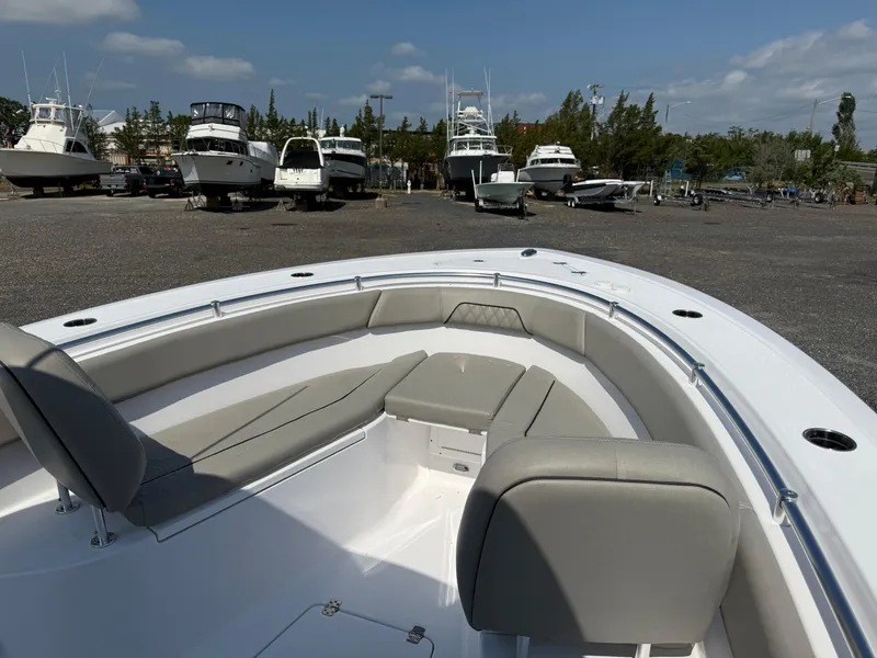 Slide: The Image of 2025 Sportsman Open 262 Center Console boat with cushioned seating, docked among other boats. - 8