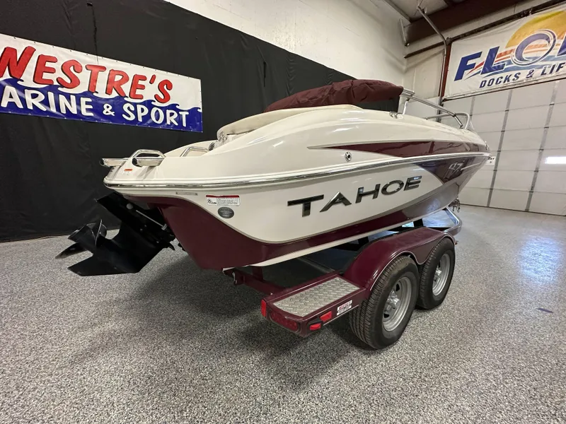 Slide: The Image of 2014 Tahoe Q7SSI boat, rear view in showroom, featuring swim platform and ladder. - 3