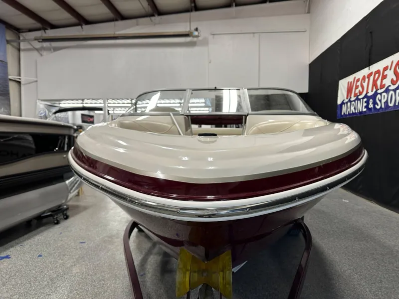 Slide: The Image of 2014 Tahoe Q7SSI boat in showroom, front view, white and maroon color scheme. - 6