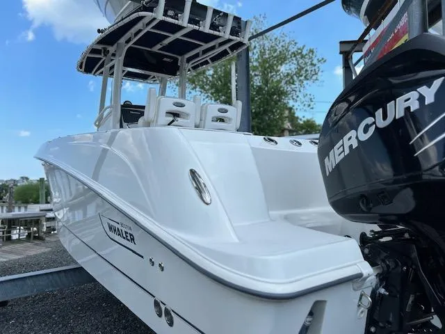 The Image of 2015 Boston Whaler 250 Outrage boat with Mercury engine, docked under a clear blue sky. - 1