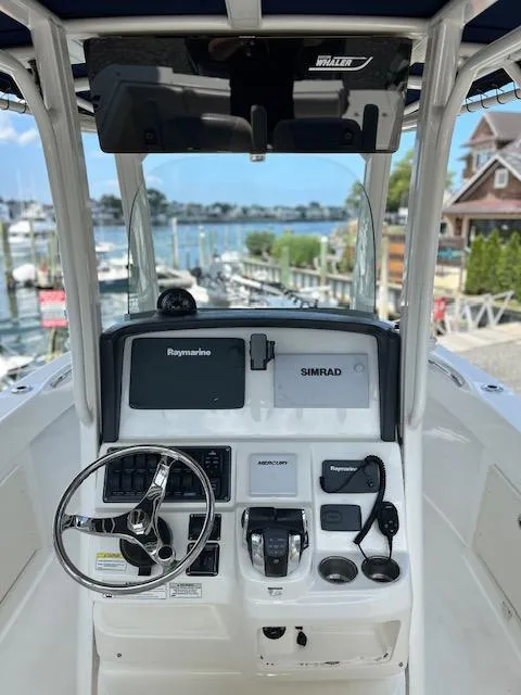 Slide: The Image of 2015 Boston Whaler 250 Outrage boat console with Raymarine and Simrad electronics, docked at marina. - 5