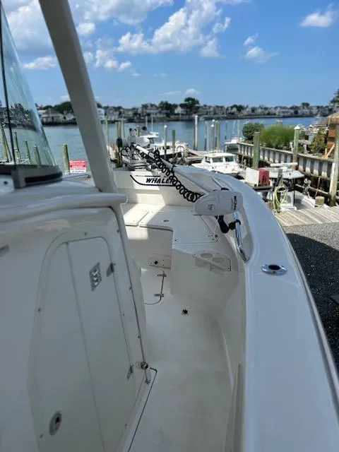Slide: The Image of 2015 Boston Whaler 250 Outrage boat docked by a scenic waterfront. - 9