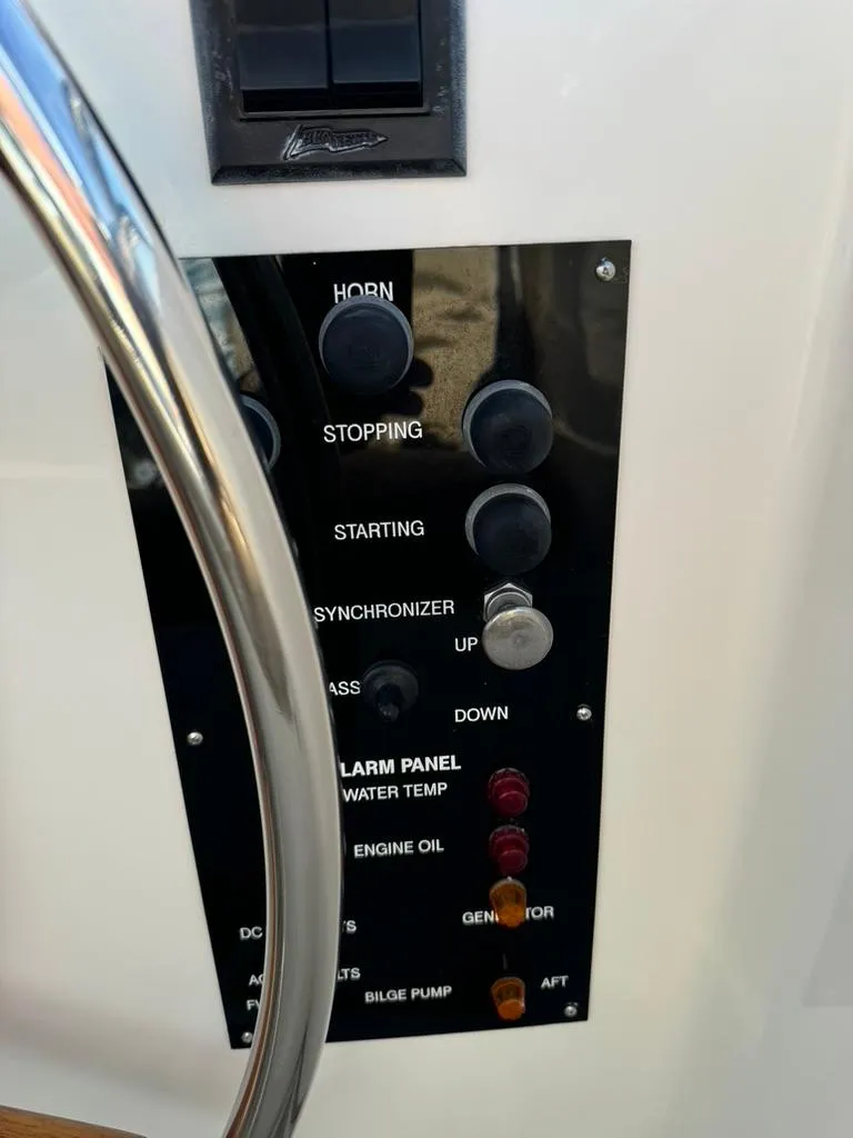 Slide: The Image of Control panel of a 1999 Grand Banks 42 Motoryacht with various switches and indicators. - 24