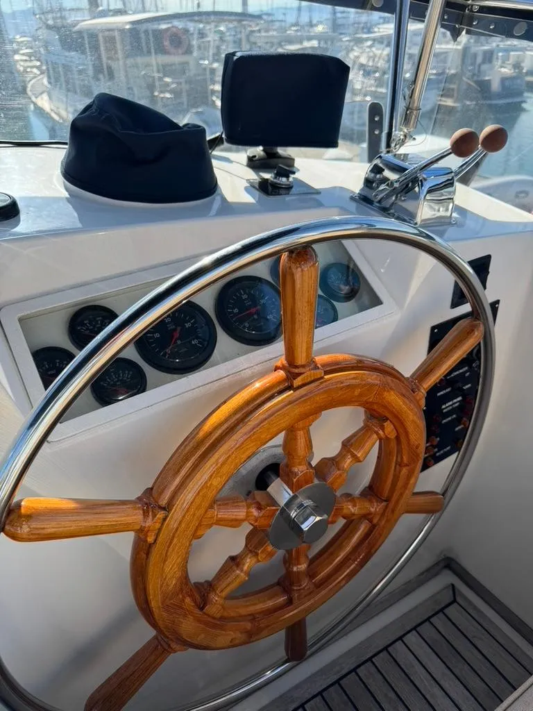 Slide: The Image of Wooden steering wheel of a 1999 Grand Banks 42 Motoryacht, with gauges and controls. - 25