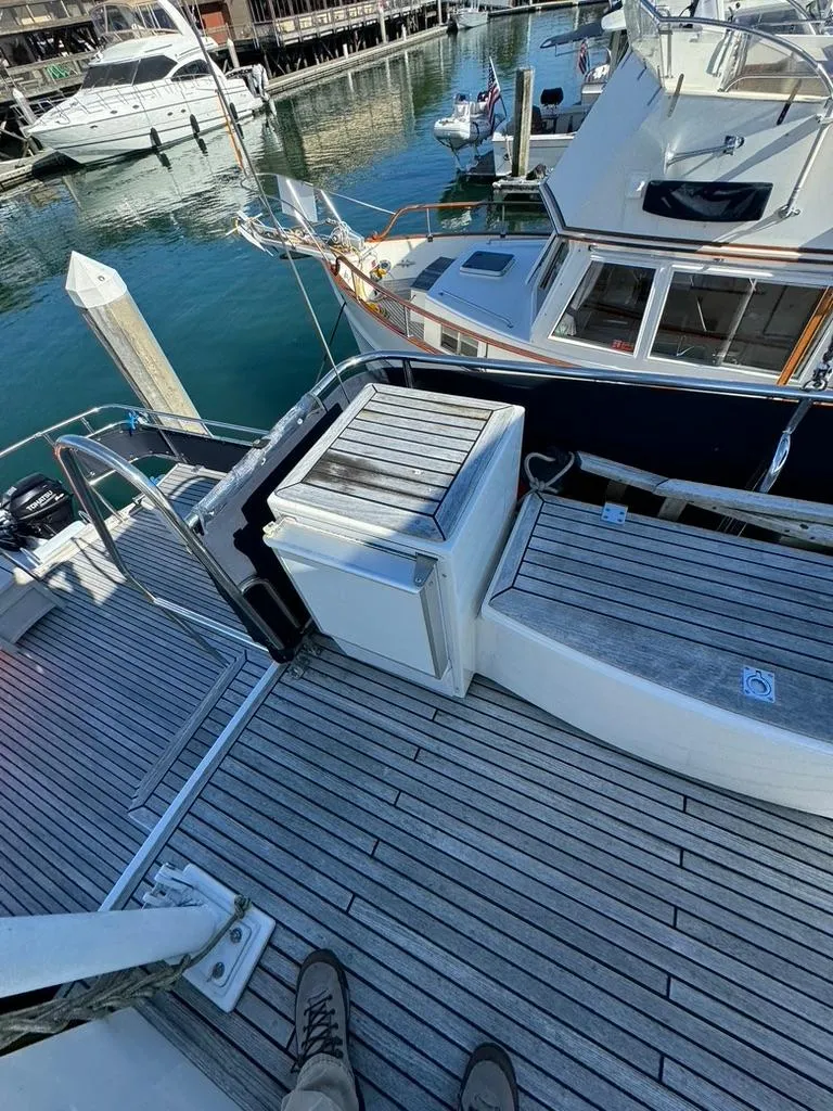 Slide: The Image of 1999 Grand Banks 42 Motoryacht docked, featuring teak deck and marina view. - 33