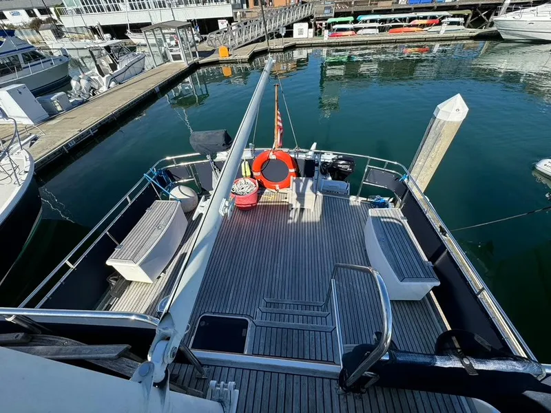 Slide: The Image of 1999 Grand Banks 42 Motoryacht docked, featuring spacious deck with seating and safety equipment. - 34