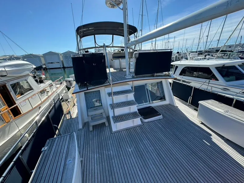 Slide: The Image of 1999 Grand Banks 42 Motoryacht with spacious deck, docked at marina under clear blue sky. - 35