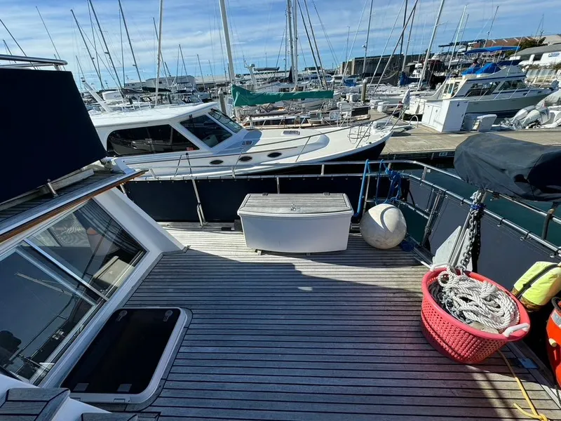 Slide: The Image of Deck of 1999 Grand Banks 42 Motoryacht in marina, featuring ropes and storage box. - 36