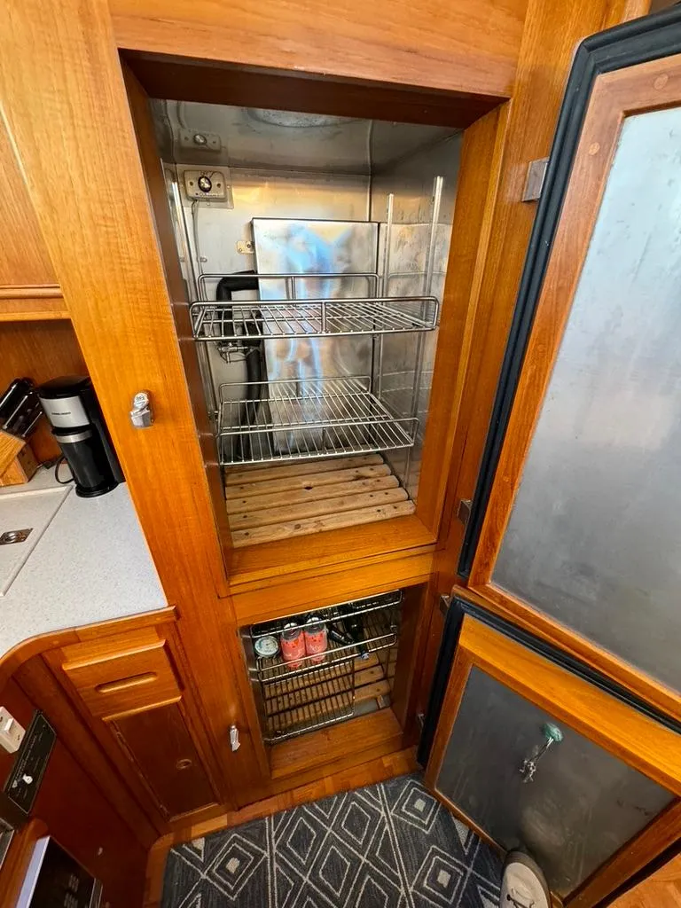 Slide: The Image of Interior of 1999 Grand Banks 42 Motoryacht showing wooden cabinetry and storage compartments. - 42