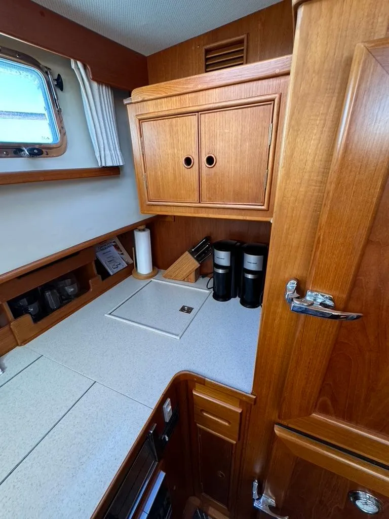 Slide: The Image of 1999 Grand Banks 42 Motoryacht kitchen with wooden cabinetry and modern appliances. - 43