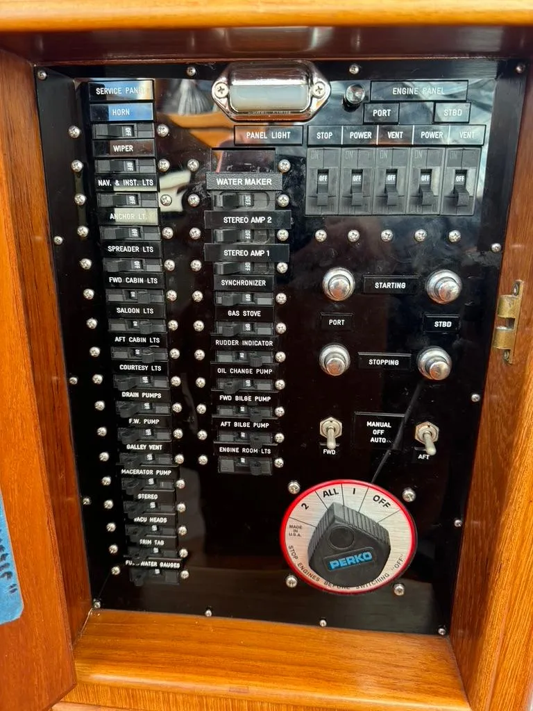 Slide: The Image of Control panel of a 1999 Grand Banks 42 Motoryacht with labeled switches and dials. - 44