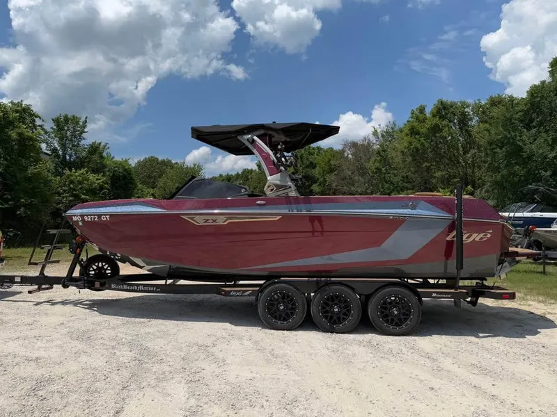 The Image of 2024 Tigé Ultré 25ZX boat on trailer, parked outdoors under a cloudy sky. - 0