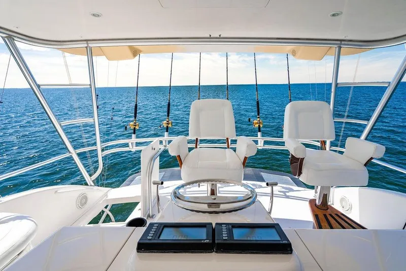 Slide: The Image of Luxury 2006 Viking 56 Convertible yacht cockpit with ocean view and fishing rods. - 10