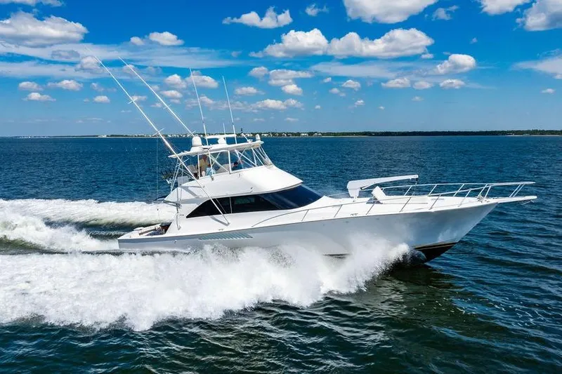 Slide: The Image of 2006 Viking 56 Convertible yacht cruising on open water under a clear blue sky. - 100