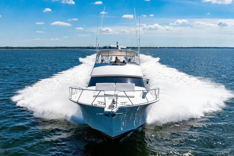 Slide: The Image of 2006 Viking 56 Convertible yacht cruising on open water under a clear blue sky. - 101