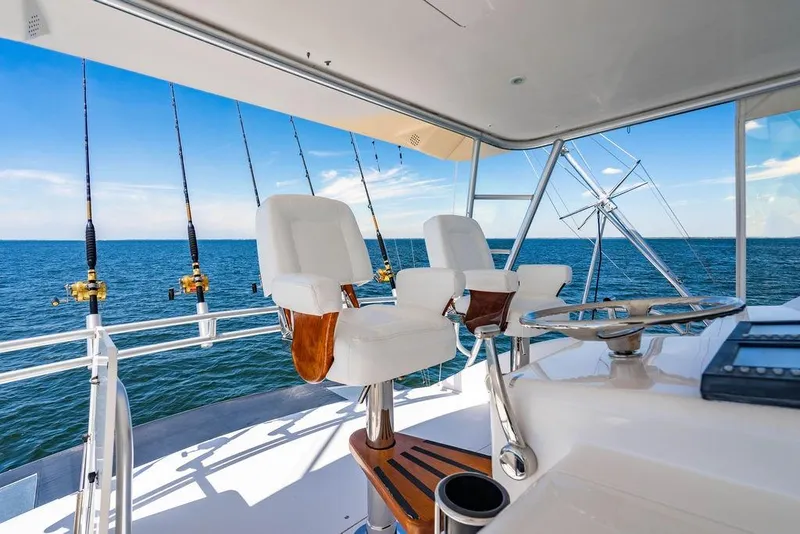Slide: The Image of Luxury Viking 56 Convertible yacht helm with ocean view, fishing rods, and captain's chairs, 2006 model. - 11
