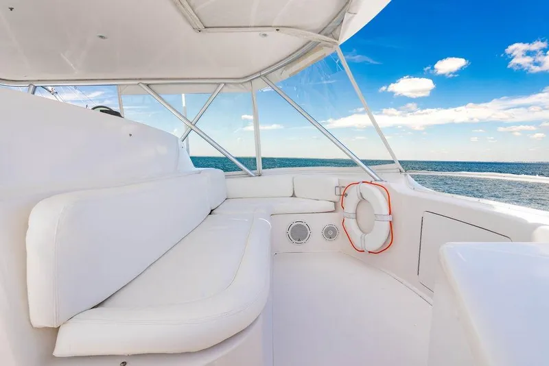Slide: The Image of 2006 Viking 56 Convertible yacht interior with white seating, ocean view, and blue sky. - 22